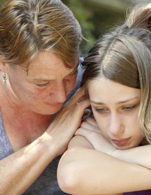 A mother consoles her teenage daughter
